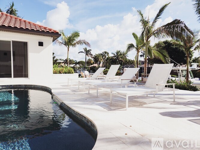 A pool with a white chair and a white building in the background.
