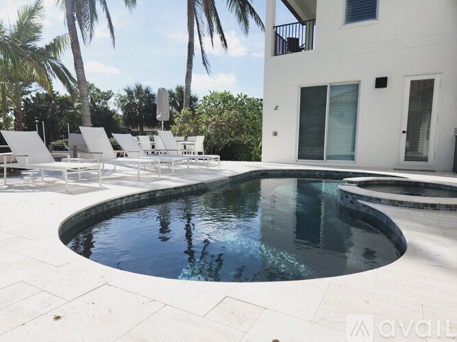 A white house with a pool in the backyard.