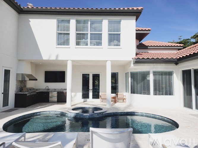 A white house with a pool in the middle of it.