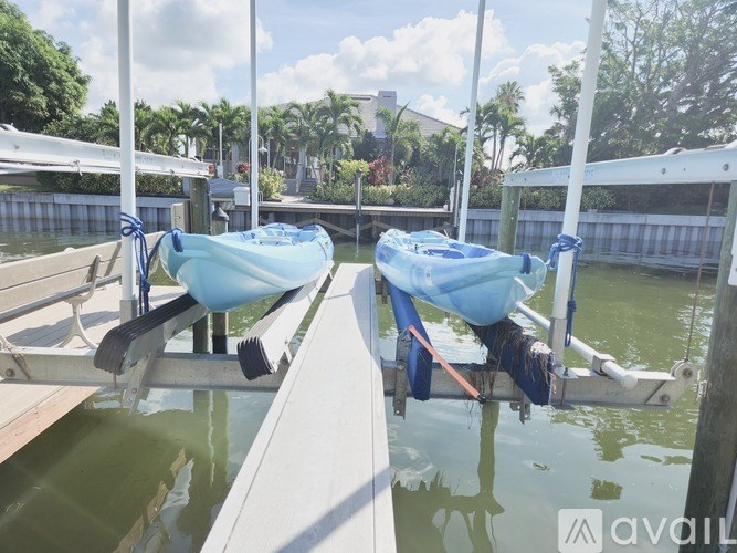 Two boats are tied to a dock on a sunny day.