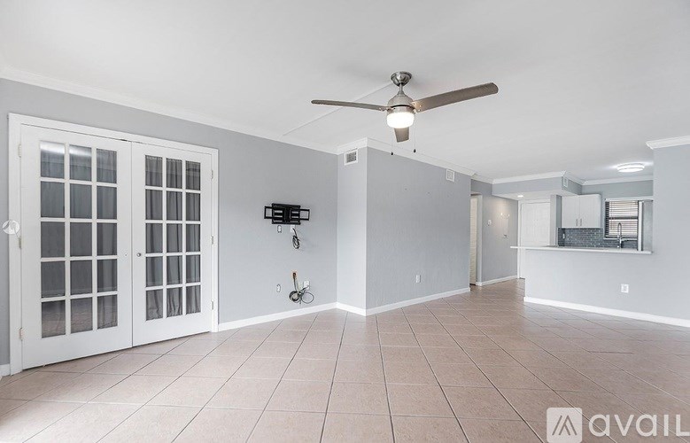 A spacious room with a ceiling fan and tiled flooring.