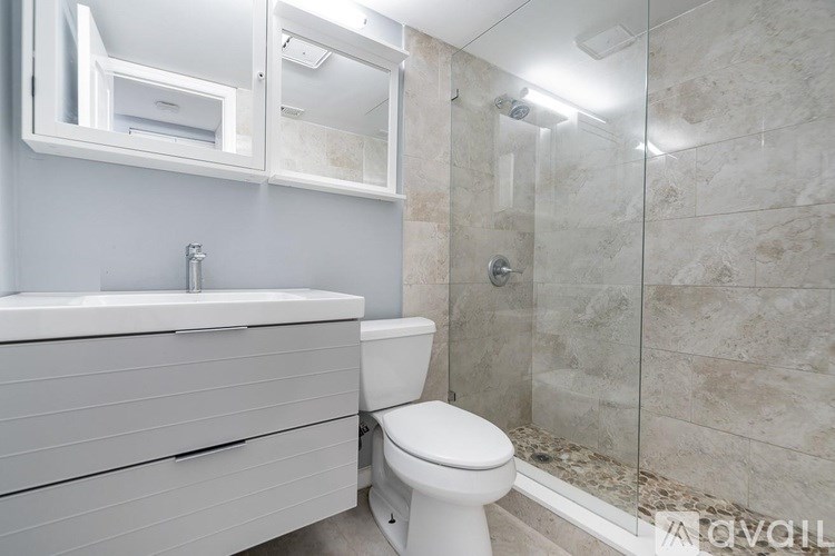 A white toilet sits next to a sink in a bathroom.