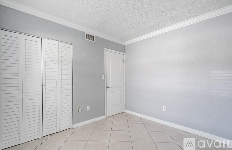 A room with a white door and a wall-mounted light fixture.