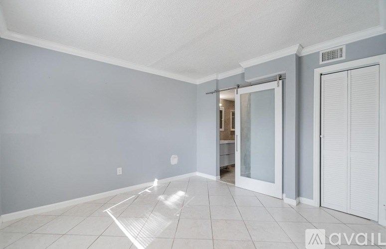 A room with a white floor and a sliding glass door.