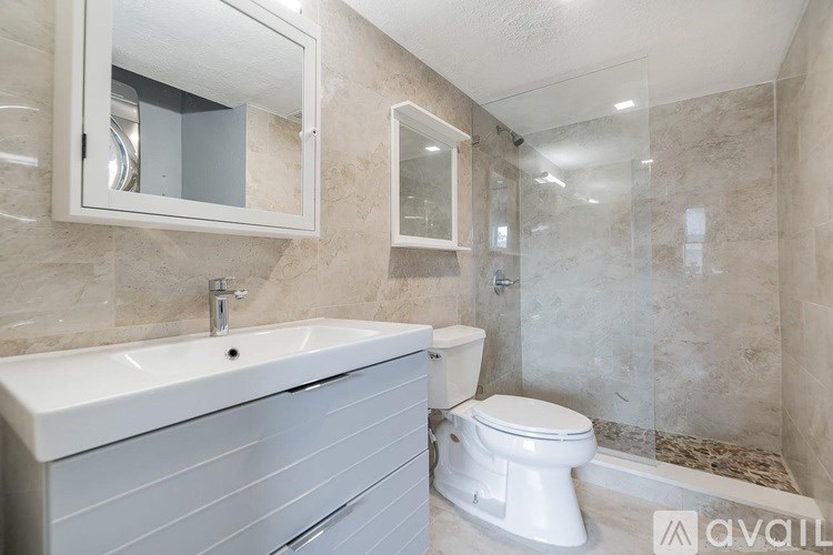 A bathroom with a white toilet and a sink with a mirror above it.