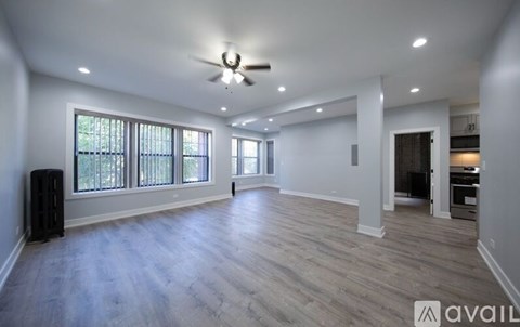 A spacious room with a ceiling fan and wooden flooring.