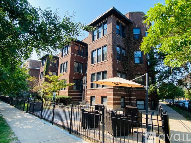 A large brick building with a black fence in front.