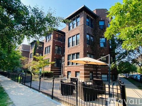 A large brick building with a black fence in front.
