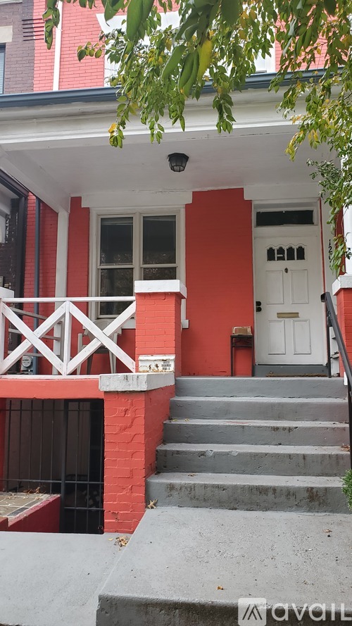 A red house with a white door and steps leading up to it.