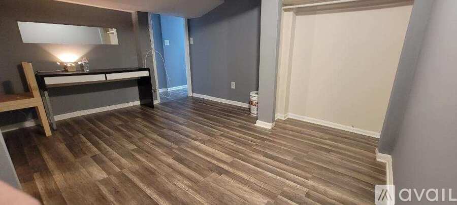 A room with wooden flooring and a bench.