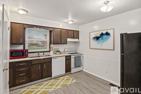 A kitchen with a white fridge, microwave, and oven.