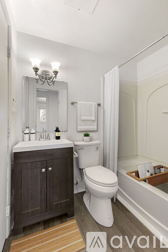 A bathroom with a toilet, sink, and mirror.