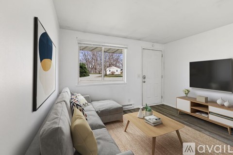 A living room with a grey couch, a coffee table, and a painting on the wall.