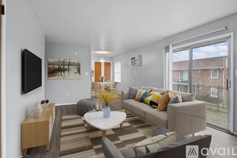 A living room with a sofa, a coffee table, and a television.