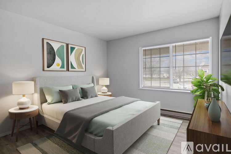 A bedroom with a large bed, two lamps, and a painting on the wall.