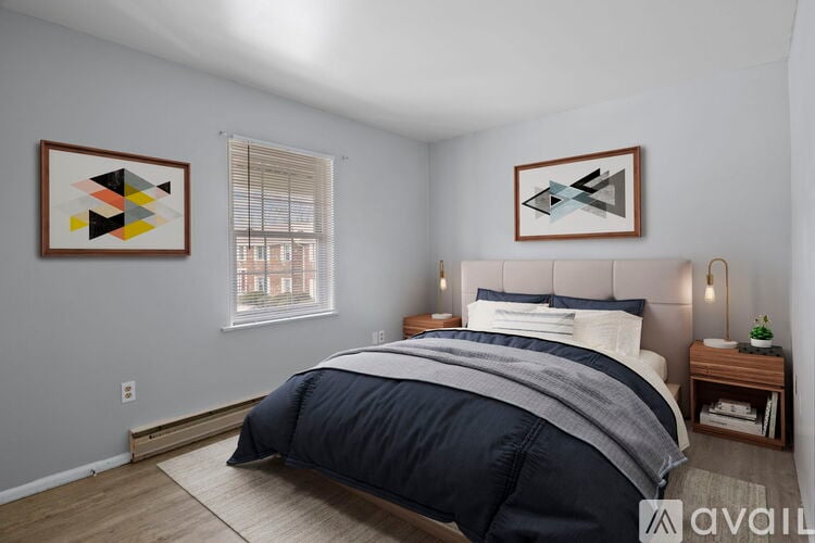 A bedroom with a large bed and two abstract art pieces on the wall.