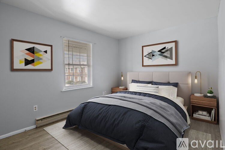 A bedroom with a large bed and two abstract art pieces on the wall.
