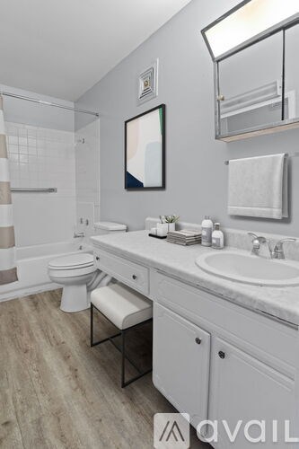 A bathroom with a toilet, sink, and mirror.