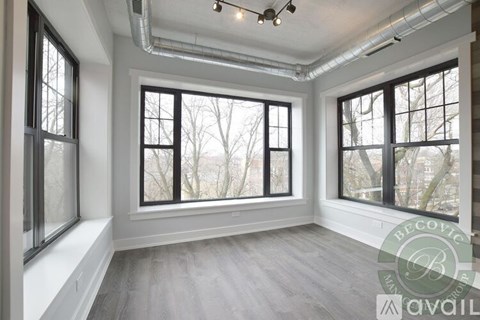 A room with large windows and a wooden floor.