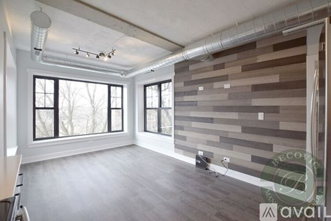 A room with a wall made of wooden planks and a window.