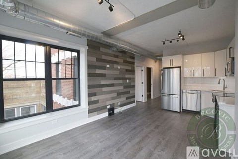 A spacious room with a grey wall and a window overlooking a building.