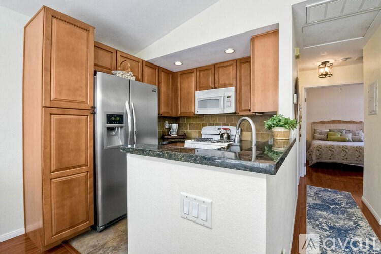 A kitchen with wooden cabinets and a stainless steel refrigerator.