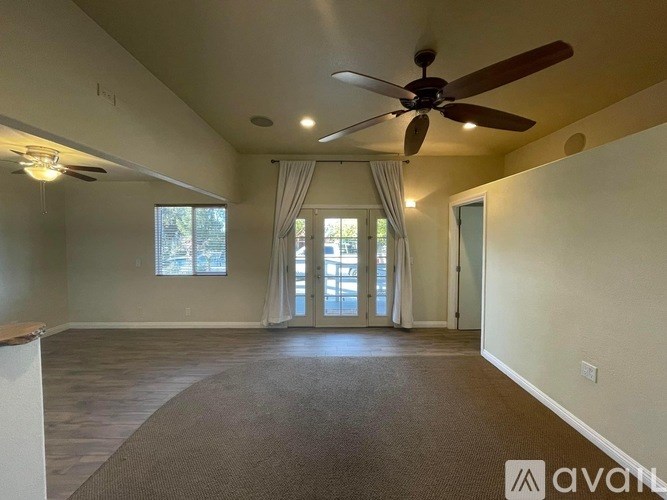 A spacious room with a ceiling fan and sliding glass doors.