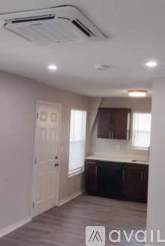 A room with a white door and a window with brown curtains.