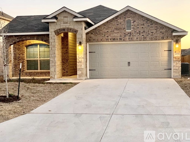 A house with a garage and a driveway in front.