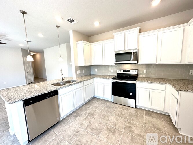 A kitchen with white cabinets and a granite countertop.