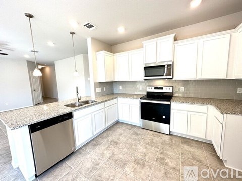 A kitchen with white cabinets and a granite countertop.