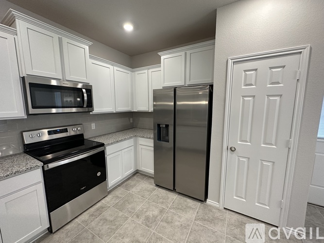 A spacious room with a ceiling fan and tiled flooring.