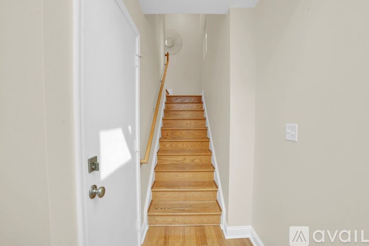 A staircase with wooden steps leading up to a white door.