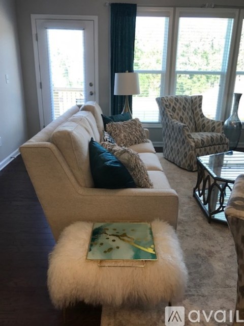 A living room with a beige couch and a patterned chair.
