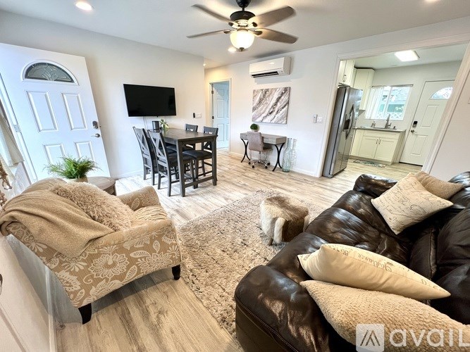 A living room with a couch, chair, and a dog.