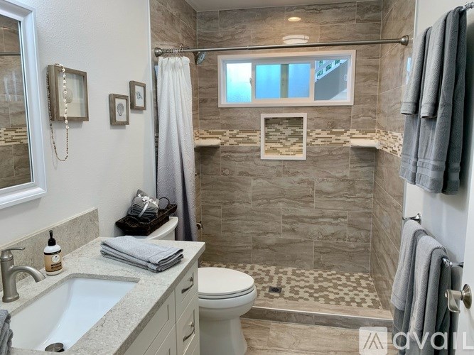 A bathroom with a toilet, sink, and shower.