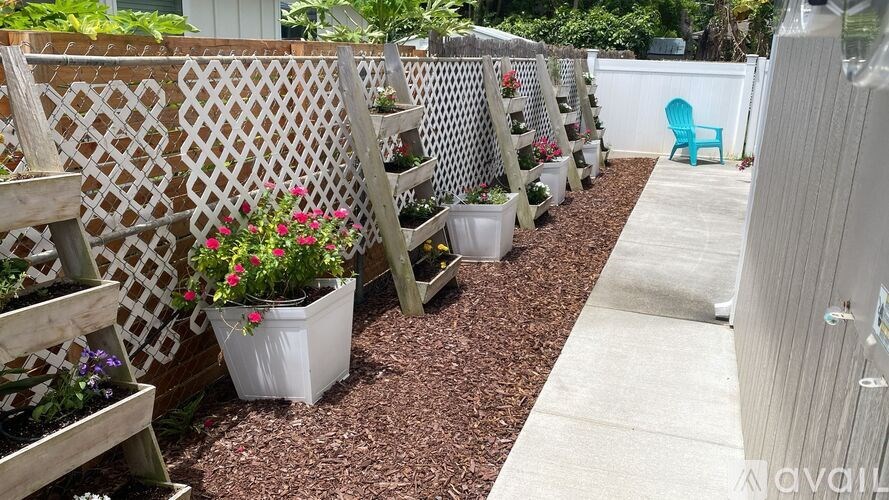 A garden with white pots and wooden trellises.