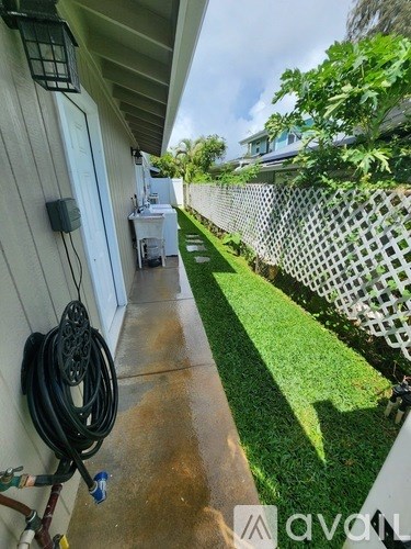 A patio with a hose hanging on the wall.