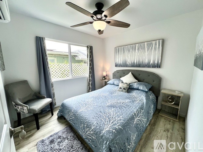 A bedroom with a bed, chair, and window.