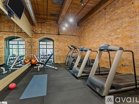 A gym with treadmills, exercise balls, and mirrors.