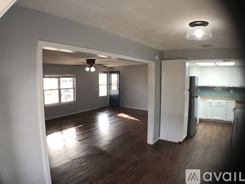 A spacious room with wooden floors and a ceiling light.