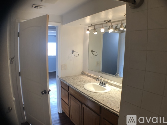 A bathroom with a sink, mirror, and lights.