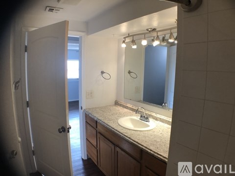 A bathroom with a sink, mirror, and lights.