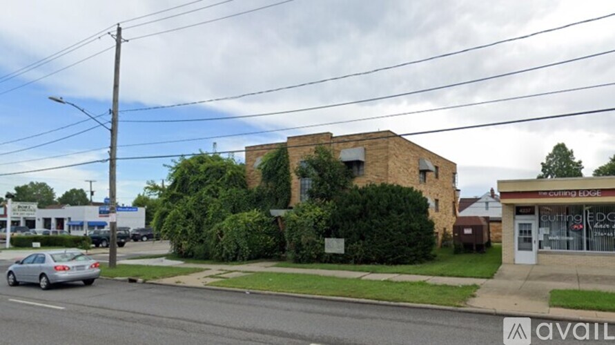 A street view with a building that has a sign that says "cutting edge" on it.