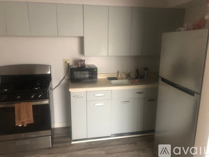A kitchen with white cabinets and a black stove top.