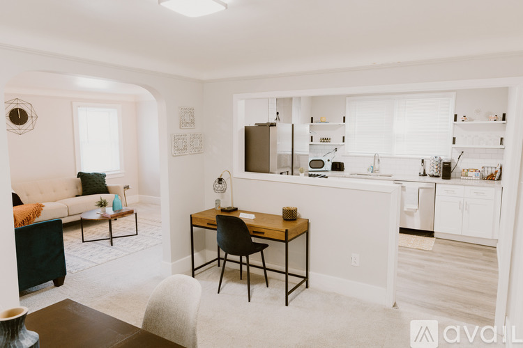 A kitchen with white cabinets and a wooden table.