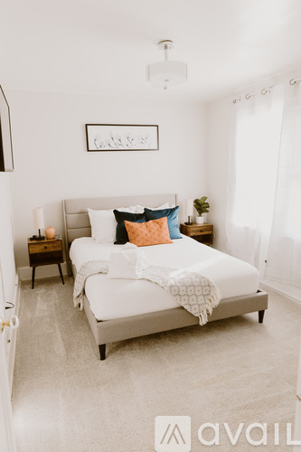 A bedroom with a bed, nightstand, and a framed picture on the wall.