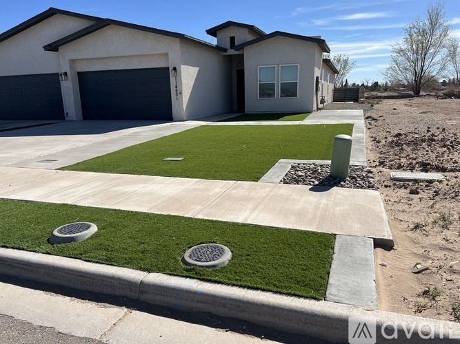 A house with a grey garage door and a white house with a grey roof.