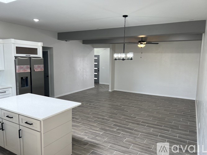 A kitchen with a white countertop and a refrigerator.