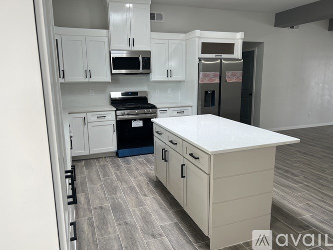 A kitchen with white cabinets and a white island.